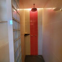 Modern bathroom with red tiled shower space