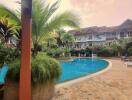 Tropical resort-style outdoor pool area with palm trees and sun loungers