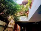 Inviting exterior view of a house with lush greenery and covered parking space