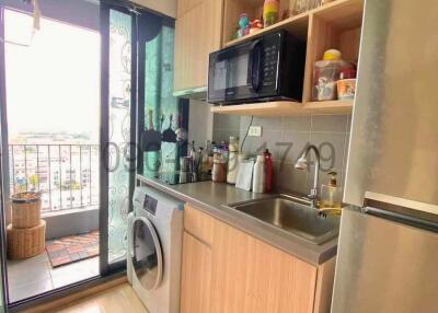 Compact modern kitchen with natural light and balcony access