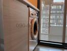 Compact Laundry Area with Washing Machine and Natural Light