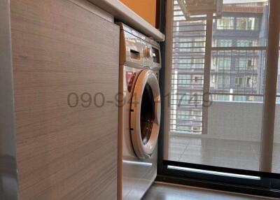 Compact Laundry Area with Washing Machine and Natural Light