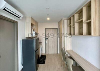 Compact modern kitchen with adjacent dining area in a well-lit apartment