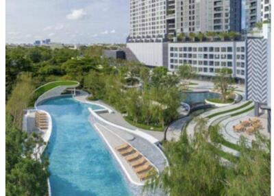 Luxurious outdoor pool with lush greenery and lounging areas in a modern apartment complex