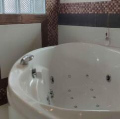Modern bathroom with whirlpool bathtub and tiled walls
