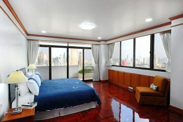 Spacious bedroom with large windows and city view