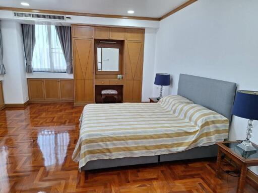 Spacious bedroom with hardwood floors and large bed