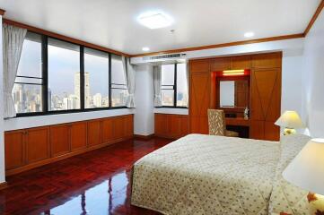 Spacious bedroom with city view and hardwood floors