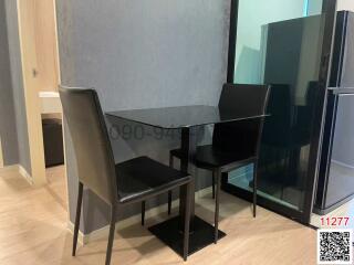 Modern dining area with glass table and black chairs