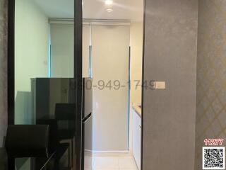 Modern corridor inside a residential apartment showing a sleek design with tiled flooring, neutral color walls, and a clearly visible entryway leading to the other parts of the home