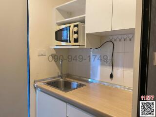 Compact kitchen with modern appliances and white cabinetry