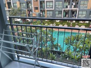 View from a balcony overlooking a pool and courtyard in a residential building complex