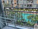 View from a balcony overlooking a pool and courtyard in a residential building complex