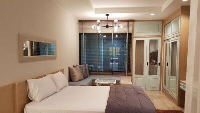 Cozy bedroom with modern interior design, including a large bed, ambient lighting, and wooden wardrobe