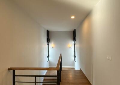 Bright hallway with wooden flooring and wall sconces