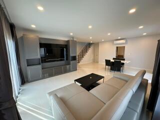 Spacious and modern living room with dining area and staircase