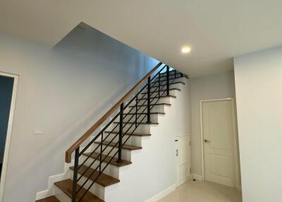 Modern staircase with wooden steps and metal railing in a residential home