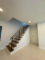 Modern staircase with wooden steps and metal railing in a residential home