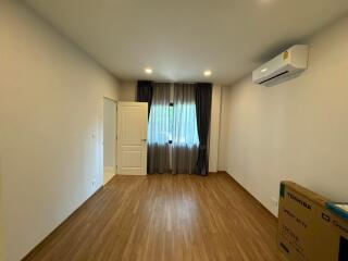 Spacious and bright bedroom with wooden flooring and air conditioning