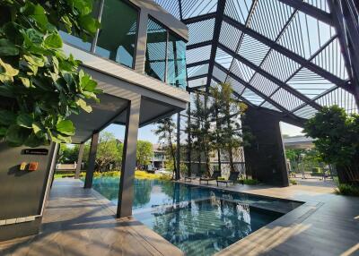 Modern outdoor pool area with lush greenery and architectural features