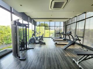 Modern home gym with a variety of exercise equipment and large windows