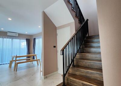 Modern staircase inside a residential home with open-plan dining area in the background