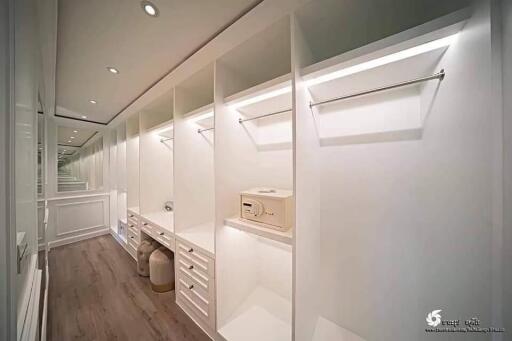 Modern walk-in closet with ample storage and built-in lighting