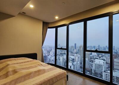 Cozy bedroom with large windows overlooking the city