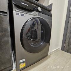 Modern front-loading washing machine in a tidy laundry area