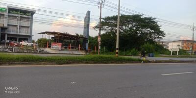 Exterior view of a building near the road taken at twilight with visible signage and vegetation