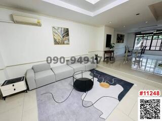 Spacious and well-lit living room with modern furnishings and air conditioning