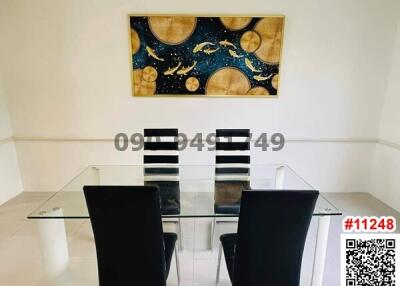 Modern dining room with glass table and contemporary art