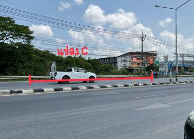 White pickup truck driving on a street with clear sky and buildings in the background