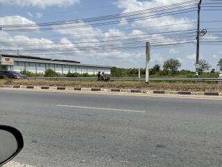 Modern single-story commercial building viewed from across the street behind a highway guardrail