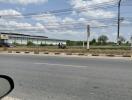 Modern single-story commercial building viewed from across the street behind a highway guardrail