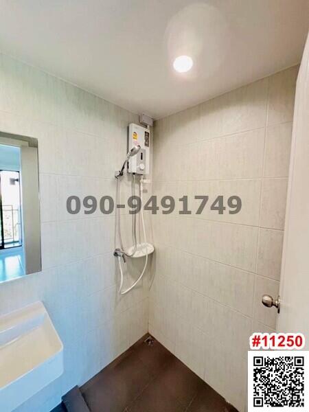 Compact bathroom with electric shower and tiled walls