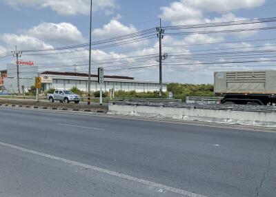 Street view of a property with nearby road and vehicles