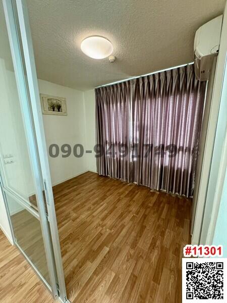 Compact bedroom with hardwood floors and curtain-covered window