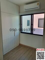 Compact bedroom with built-in wardrobe and air conditioning unit