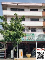 Exterior view of a multi-story residential building with commercial spaces on the ground floor.