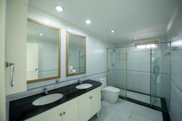 Spacious bathroom with dual sinks and glass shower