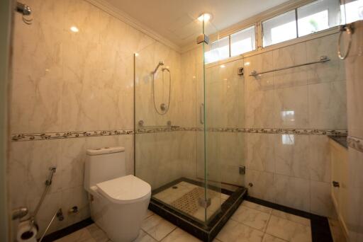 Modern bathroom with glass shower enclosure and marble tiles