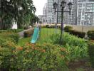 Lush green outdoor space with playground equipment and high-rise buildings in the background