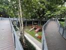 Wooden deck pathway with benches and greenery in an outdoor apartment common area