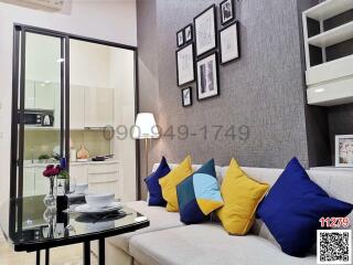 Cozy living room with kitchen view, modern furnishings, and decorative wall art