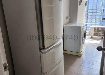 Compact kitchen space with a refrigerator and washing machine