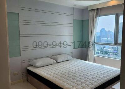Spacious master bedroom with natural light and city view