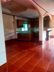 Spacious kitchen with red tiled flooring and modern appliances