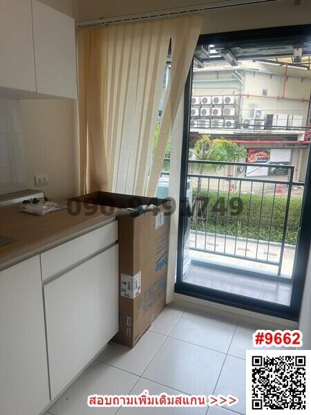 Compact kitchen with light cabinetry and sliding glass door leading to balcony