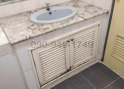 Compact bathroom with marble sink and tiled flooring